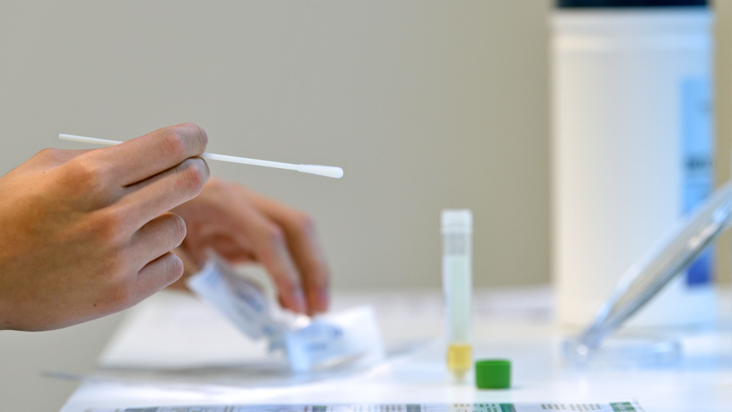 Person unwrapping COVID-19 swab testing stick