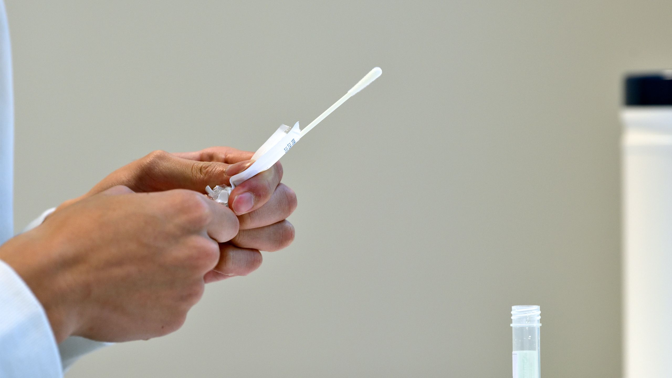Person unwrapping a COVID-19 testing swab stick