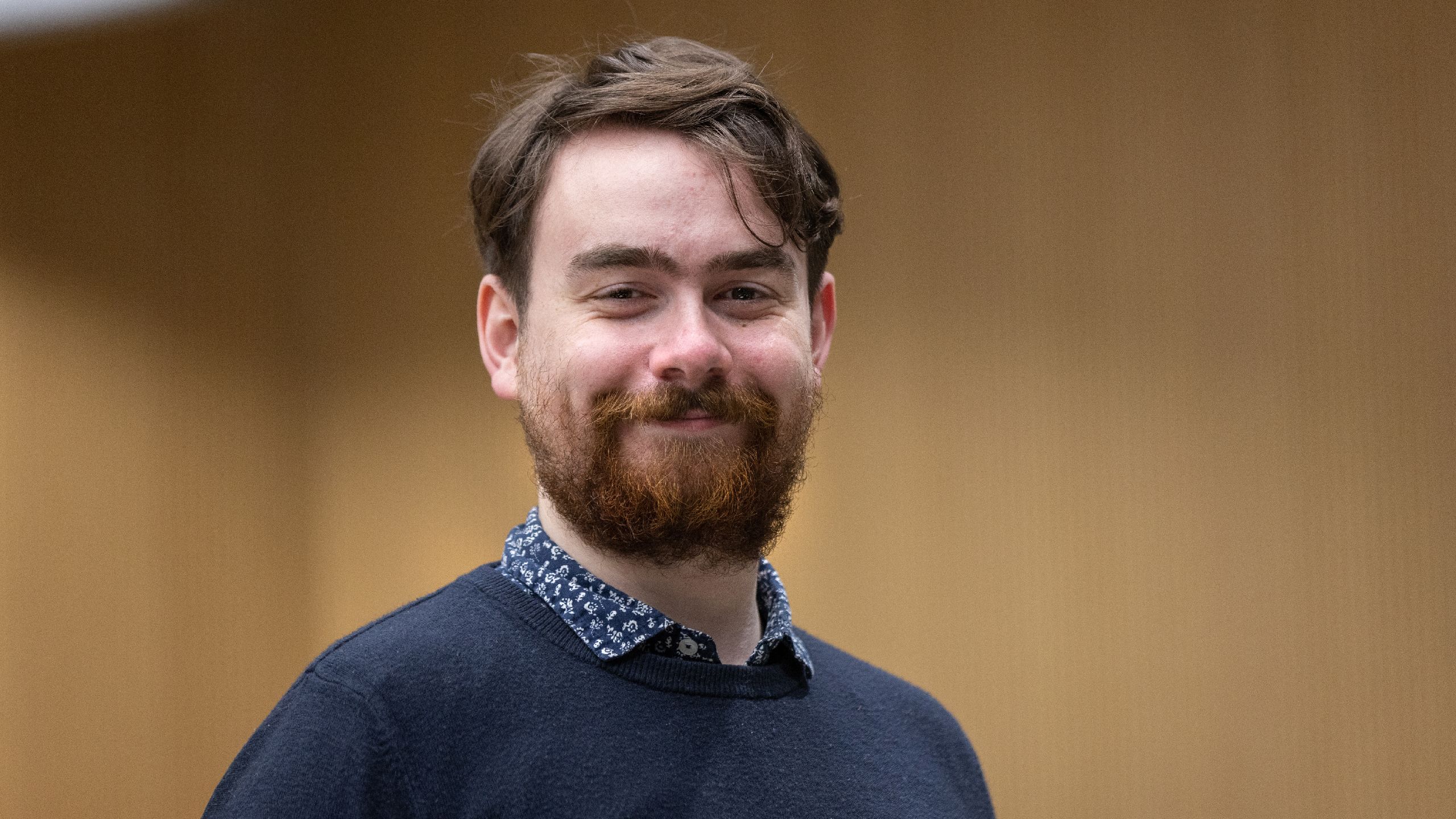 Gilbert smiling in a blue jumper