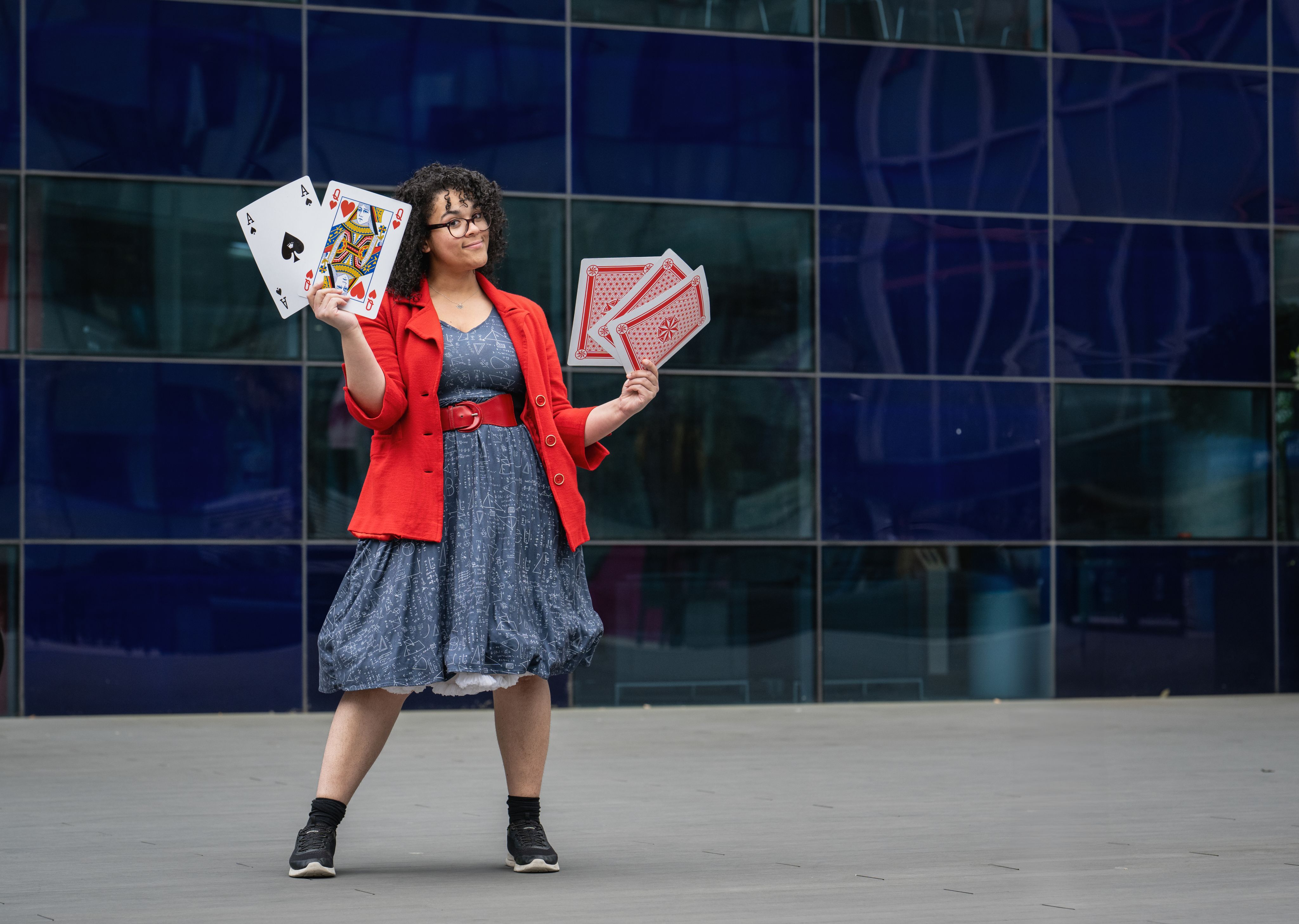 Vanessa holding large playing cards which were used as props in her engagement activities.