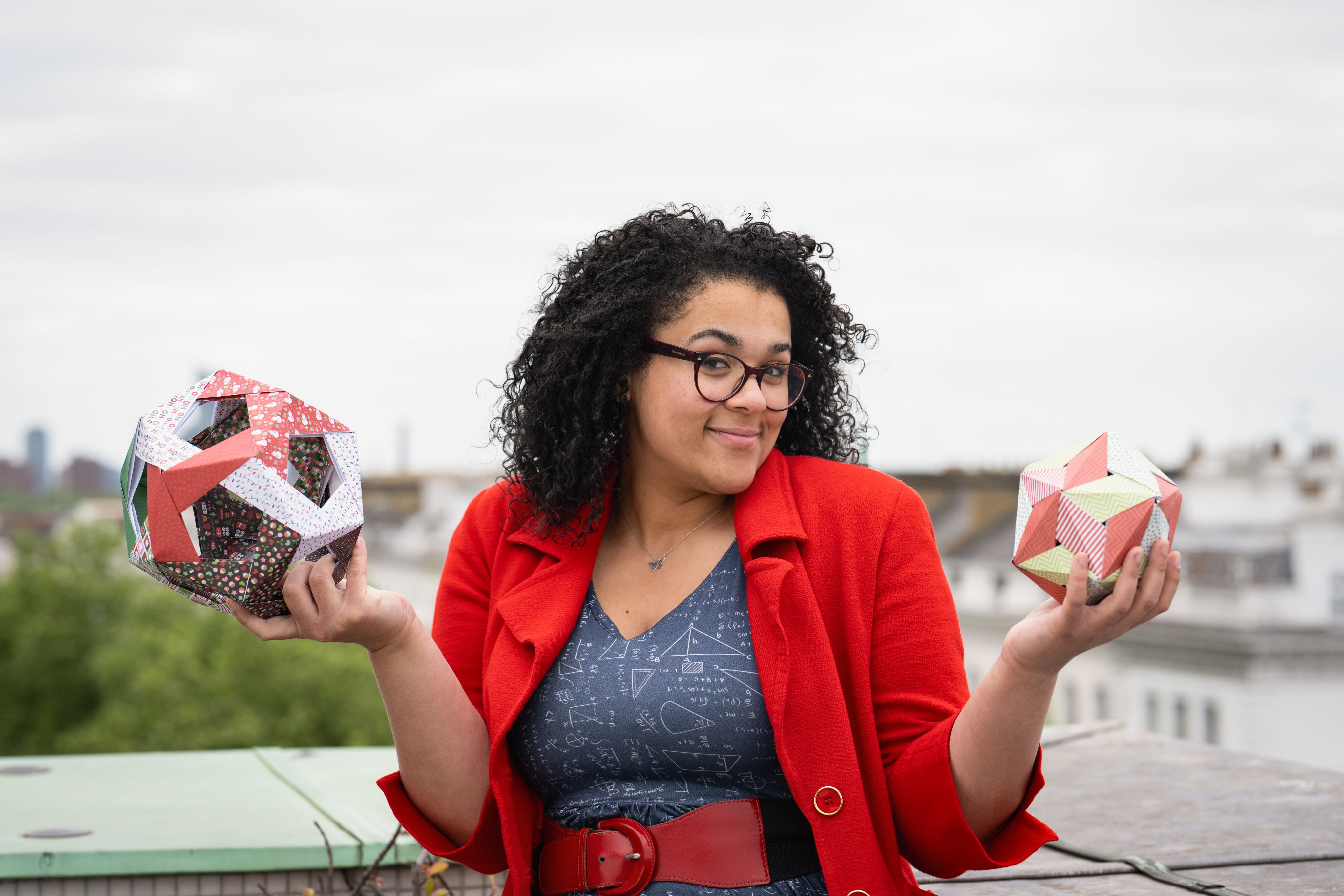 Vanessa shrugging with geometric shapes in hand.