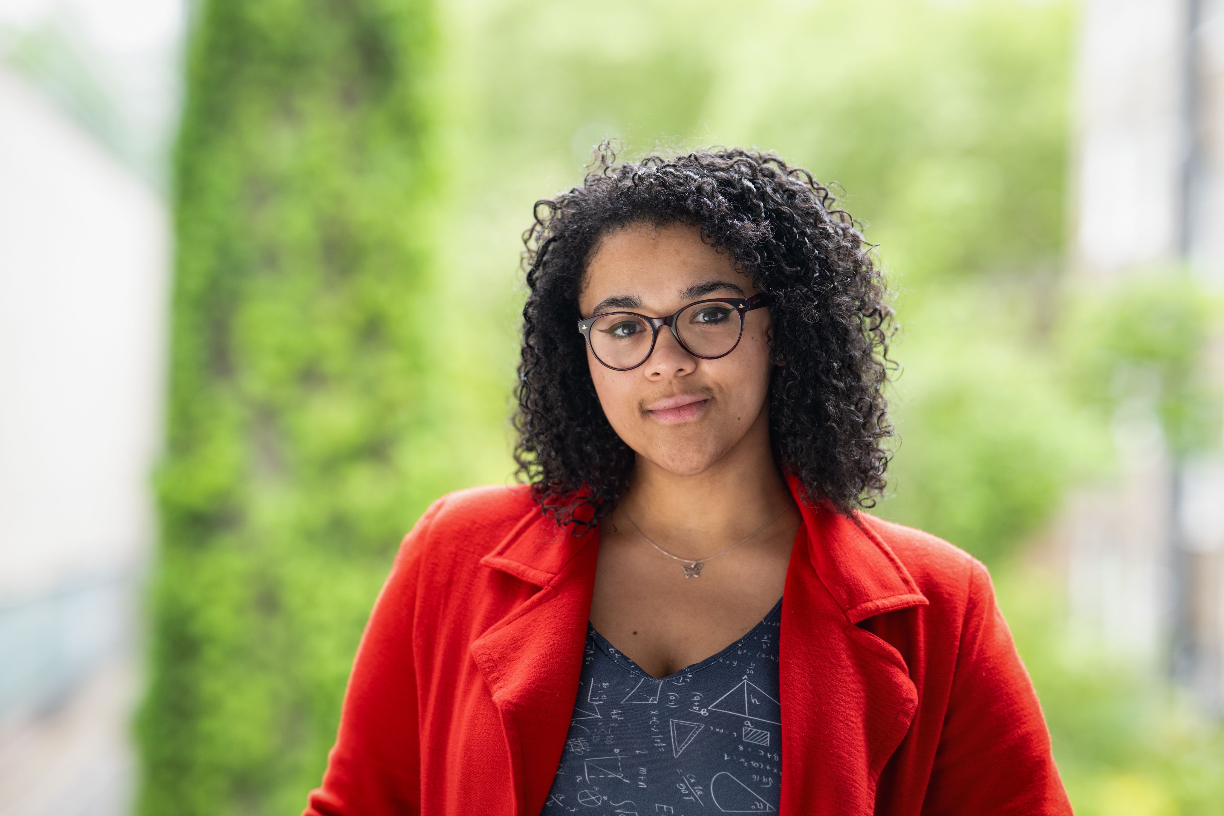 Vanessa smiling in front of a green background.
