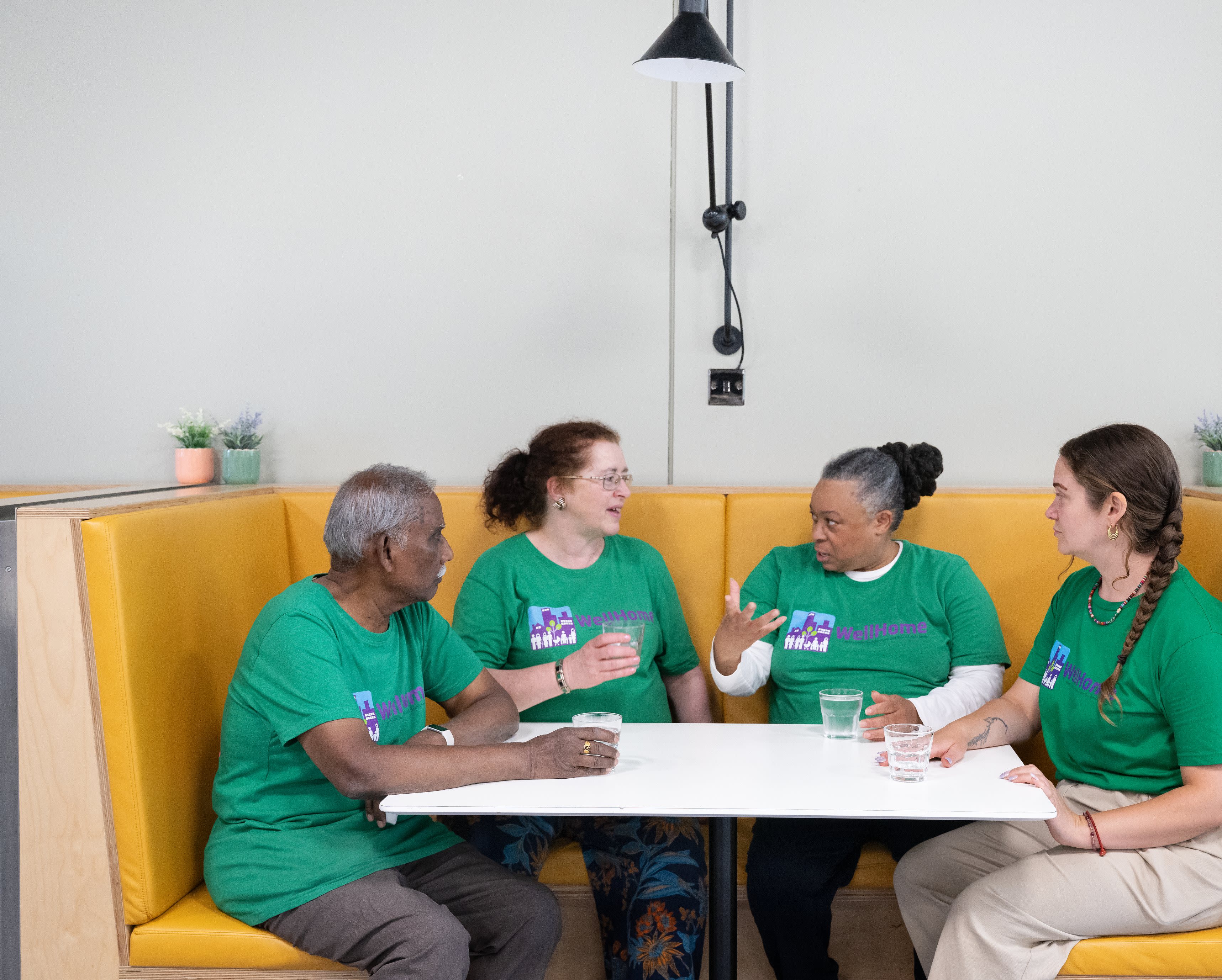 Four Ambassadors engaged in conversation while seated in a booth in The Invention Rooms.